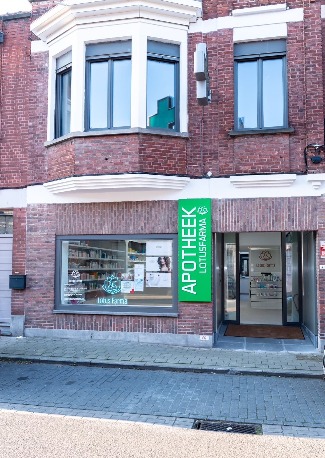 The green APOTHEEK storefront of LotusFarma in Izegem